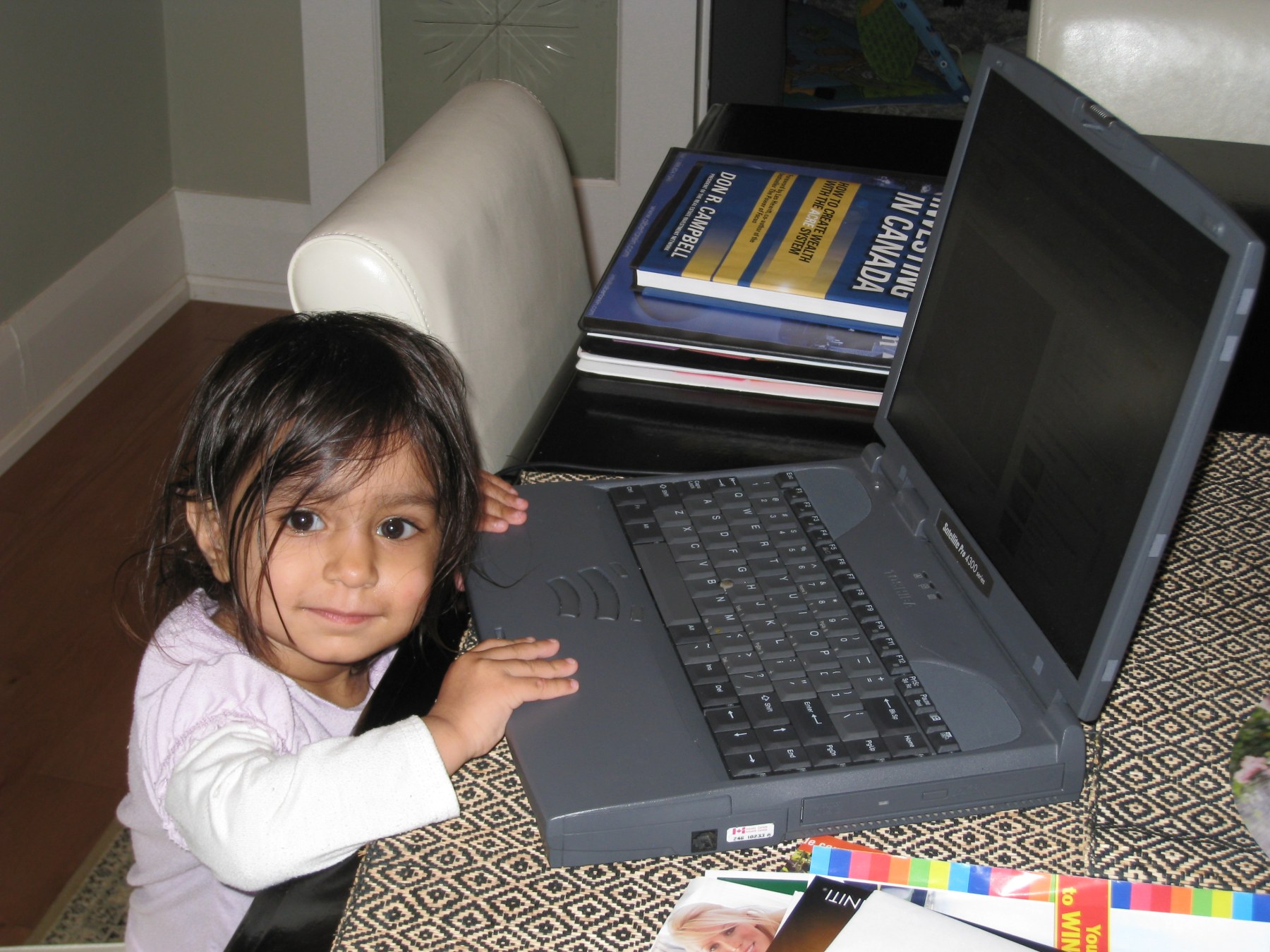 Arissa as a toddler at a laptop