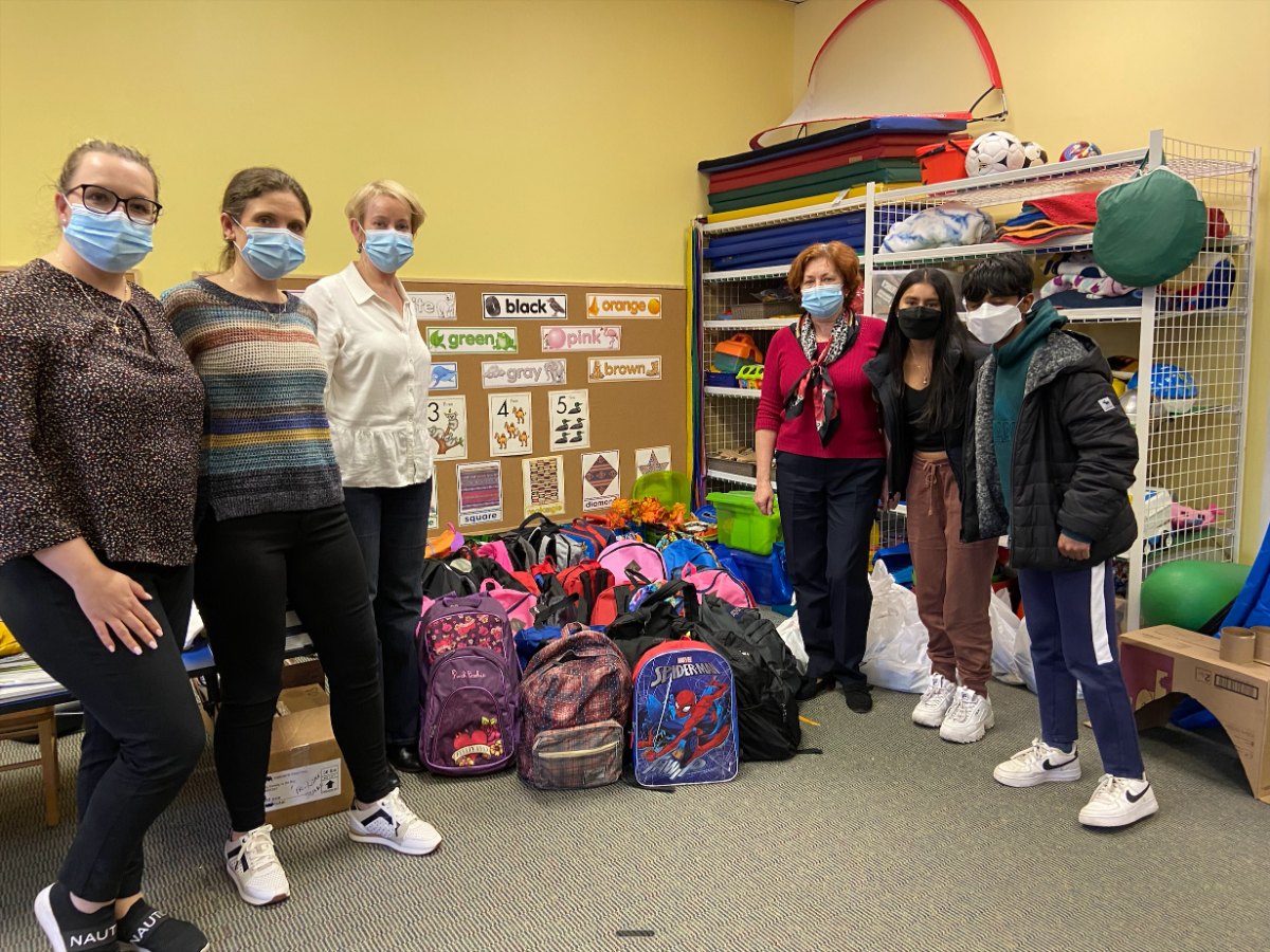 Volunteers delivering backpacks of school supplies