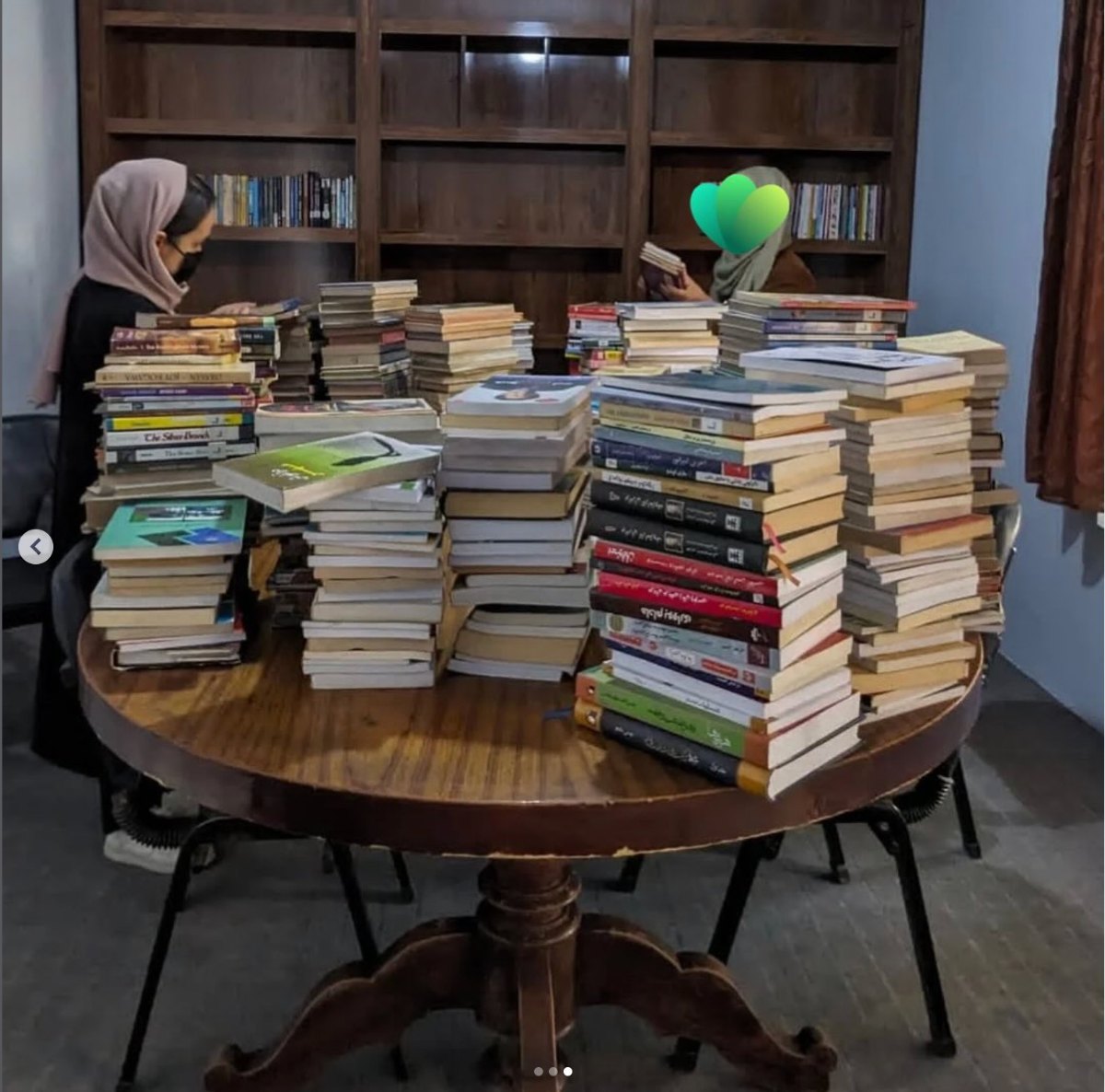 Stacks of donated books on a table for the Code Green Afghanistan project