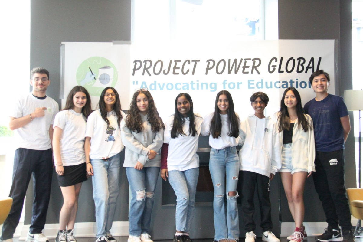 The Project Power Global team in front of the PPG banner